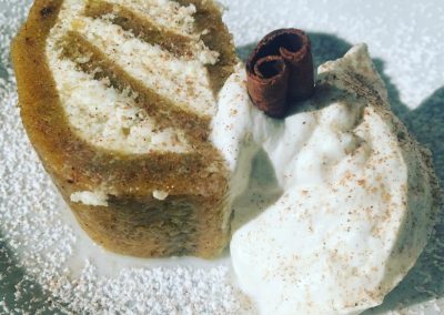 Spiced pumpkin roll with cheesecake filling; served with softly whipped cream and cinnamon